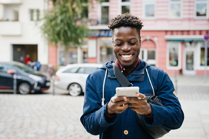 Man on downtown street looking at mobile phone