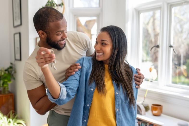 Happy couple holding keys to their new house