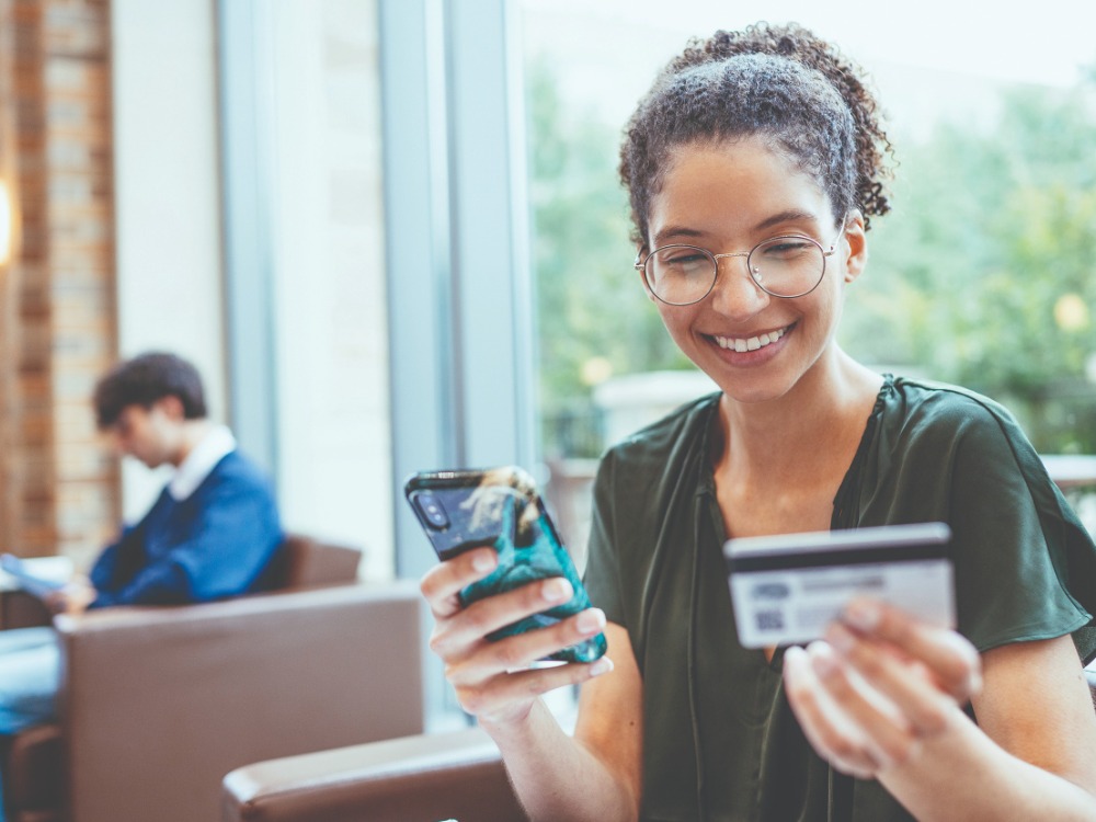Teenage girl with phone and debit card